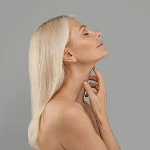 woman lifting her chin up and touching her neck